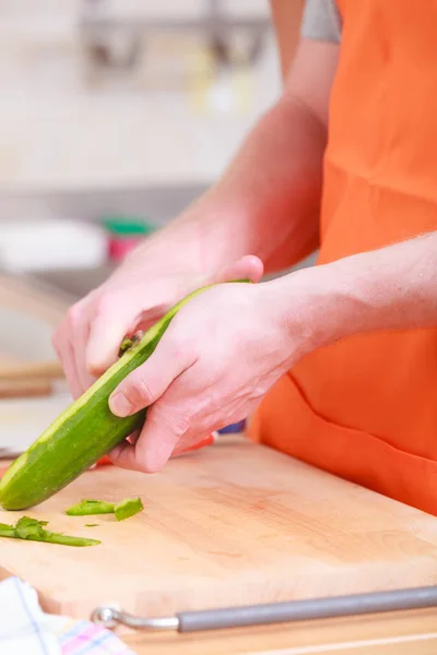 Hombre preparando verduras ensalada pelado pepino — Foto de Stock