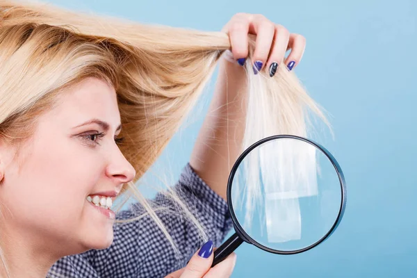 Donna che guarda i capelli attraverso lente d'ingrandimento — Foto Stock