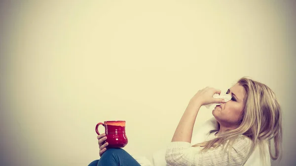 Mujer enferma teniendo gripe acostada en un sofá —  Fotos de Stock