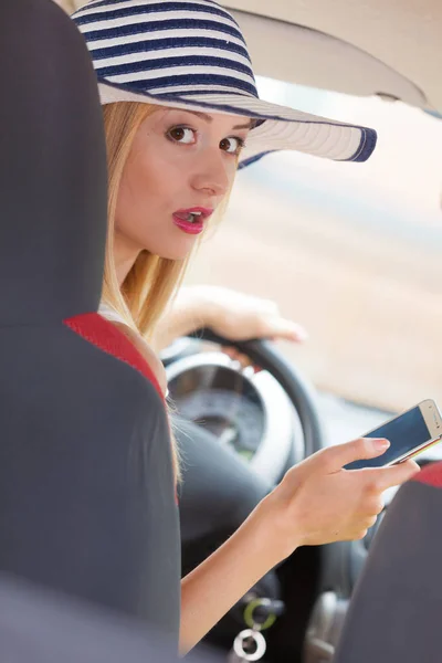 Mujer usando el teléfono mientras conduce su coche — Foto de Stock