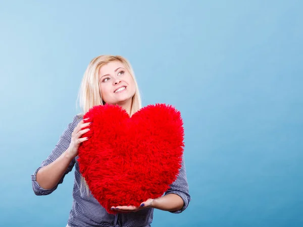 Mujer feliz sosteniendo almohada roja en forma de corazón — Foto de Stock