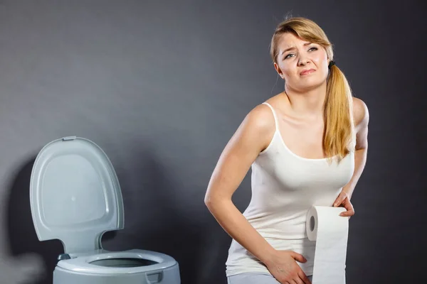 Kvinna med händer som håller henne grenen i toalett — Stockfoto