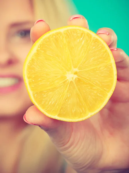 Woman holding fruit lemon or orange