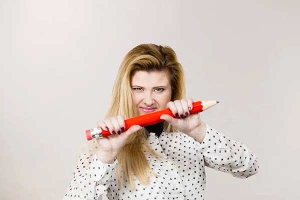 Angry woman holds big pencil in hand — Stock Photo, Image