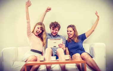 Evde tablet ile başarılı mutlu arkadaşlar.