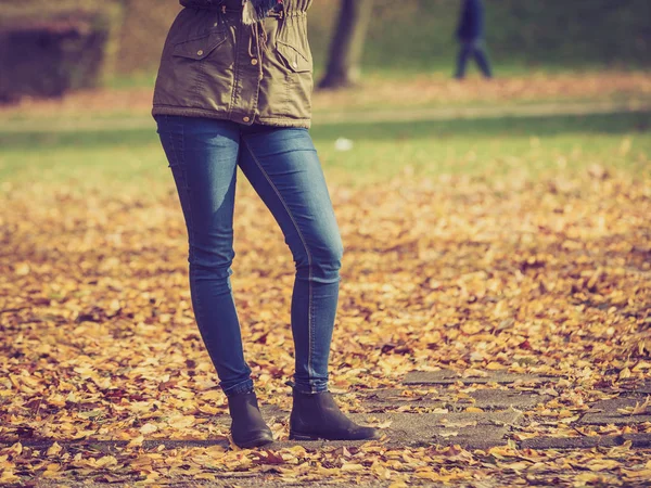 Benen van de vrouw permanent in herfst park — Stockfoto