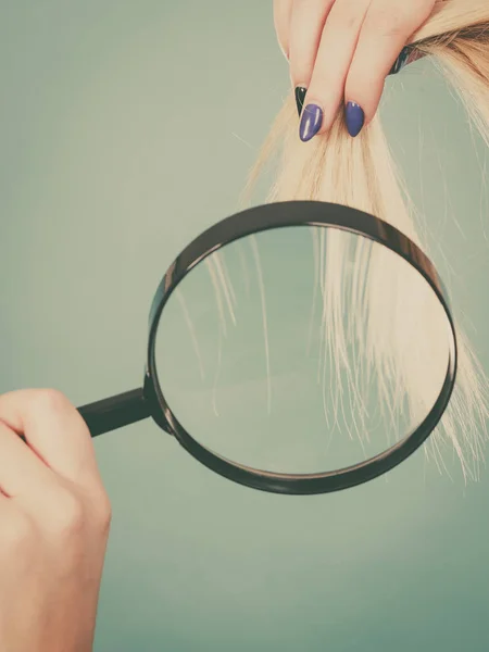 Mujer mirando el cabello a través de lupa — Foto de Stock