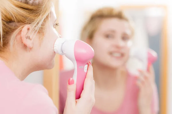 Mulher feliz usando escova de limpeza facial — Fotografia de Stock