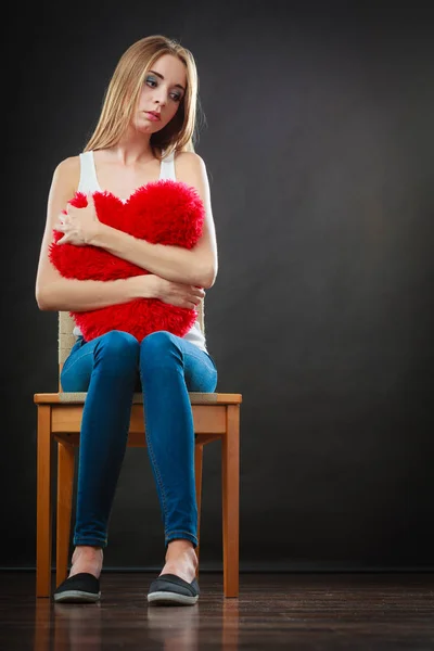 Triste mulher infeliz segurando travesseiro coração vermelho — Fotografia de Stock