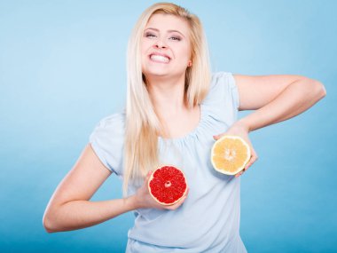 Kırmızı ve yeşil greyfurt tutan kadın