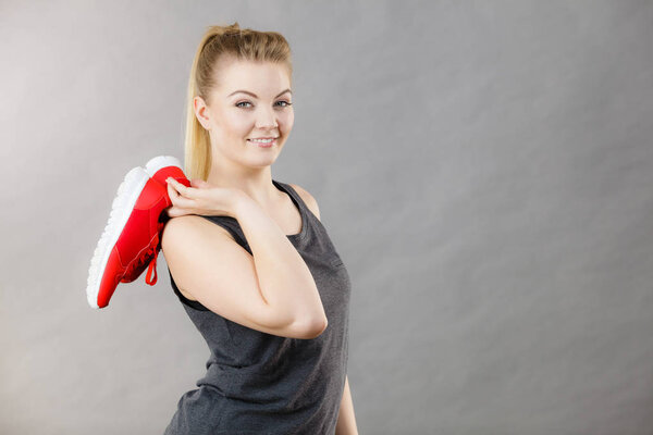 Happy woman presenting sportswear trainers shoes