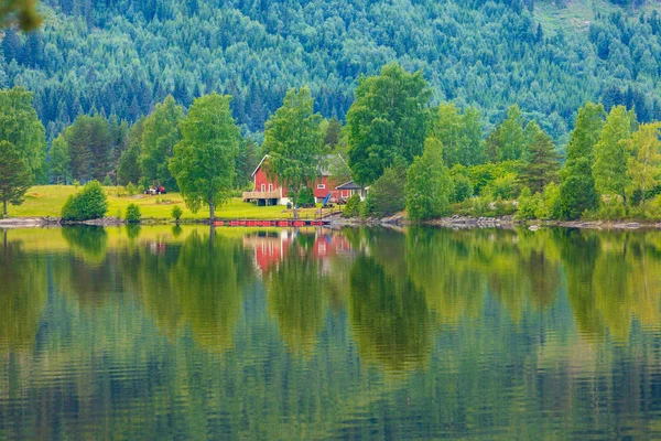 Casas de campo norueguesas em montanhas na costa do lago — Fotografia de Stock