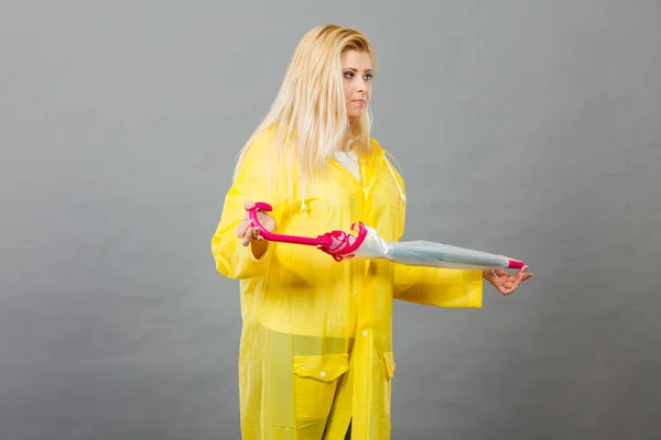 Mujer infeliz usando impermeable sosteniendo paraguas cerrado — Foto de Stock