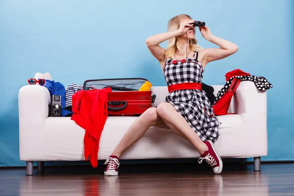 Молодая женщина собирает чемодан на диване — стоковое фото