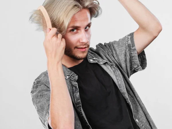 Homem com corte de cabelo elegante pentear seu cabelo — Fotografia de Stock