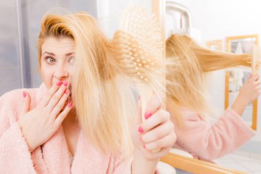 Saçları fırçalama sabahlık giyen şok kadın