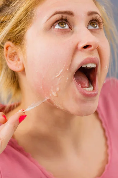 woman removing peel off mask from her face