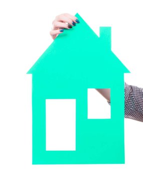 Yeşil ev modeli tutan el.