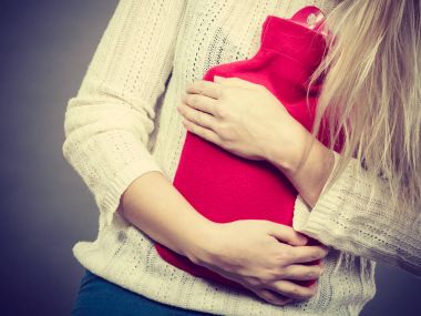 Holding sıcak su şişesi kadının duygu mide krampları