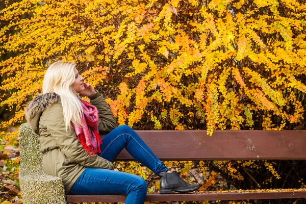 Kobieta, relaksujący siedzący na ławce w parku jesienny — Zdjęcie stockowe