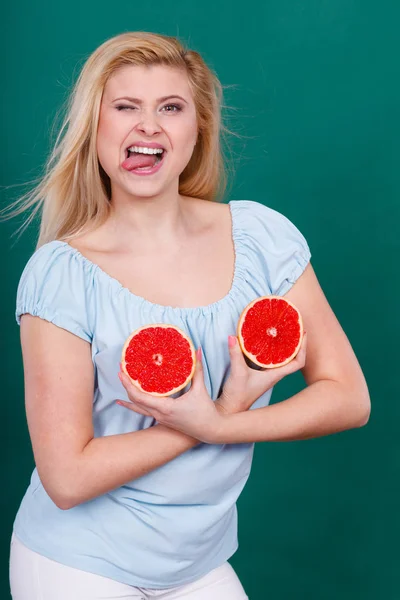 Woman holds grapefruit citrus fruit on breast — Stock Photo, Image