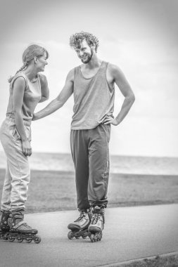 Çift birbirine bakarak rollerskates giyiyor