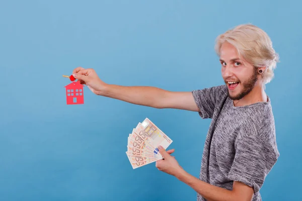 Man holding money and keys to house