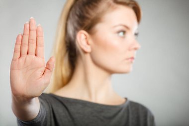 Female shows stop sign by her hand. clipart