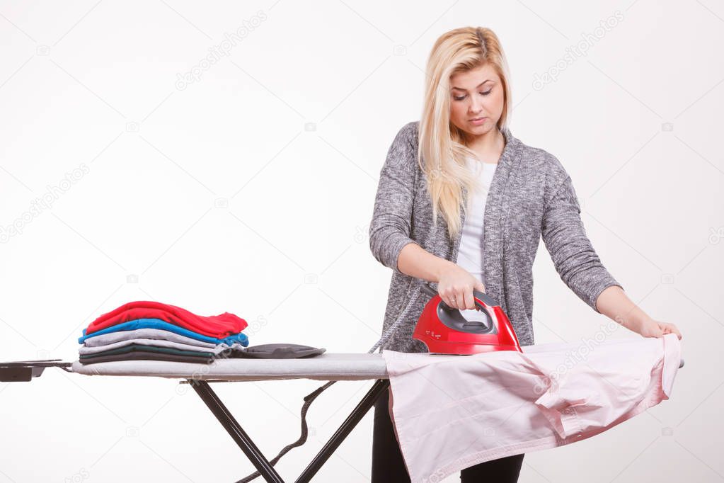 Woman holding iron about to do ironing