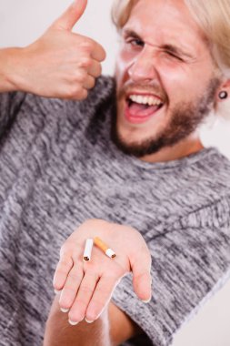 Başparmak telafi palm üzerinde kırık sigara olan adam