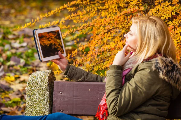Nő ül a padon park tabletta segítségével pihentető — Stock Fotó