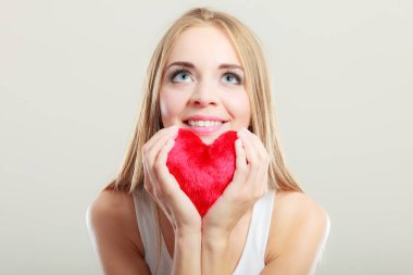 Gülümseyen kadın holding kırmızı kalp aşk sembolü