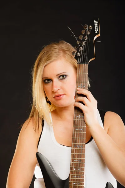 Blonde woman holding electric guitar, black background — Stock Photo, Image