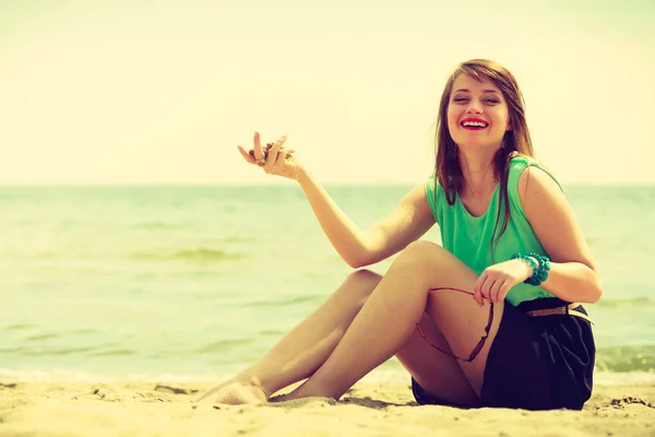 海の近くのビーチの上に座って幸せな女 — ストック写真