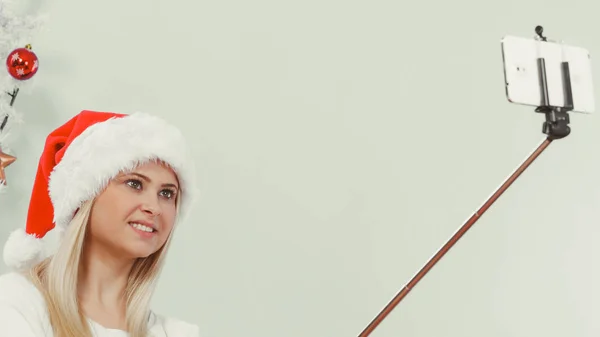 Woman in Santa hat taking Christmas selfie — Stock Photo, Image