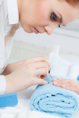 Güzellik salonunda manikür yaptıran bir kadın..