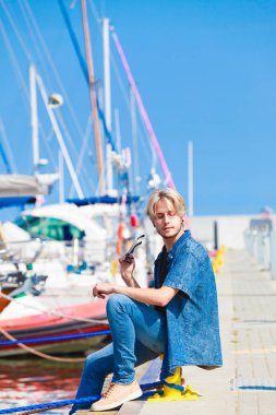 Yaz aylarında liman oturan sarışın adam
