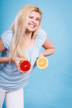 Kırmızı ve yeşil greyfurt tutan kadın