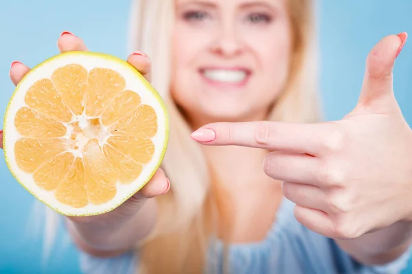 Женщина указывает на цитрусовые грейпфруты — стоковое фото