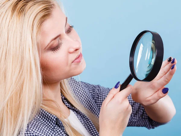 Vrouw op zoek naar nagels door vergrootglas — Stockfoto