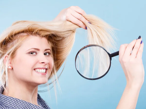 Donna che guarda i capelli attraverso lente d'ingrandimento — Foto Stock