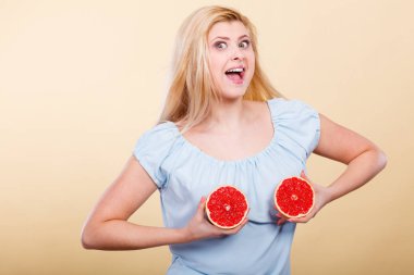 Kırmızı greyfurt meme üzerinde tutan kadın