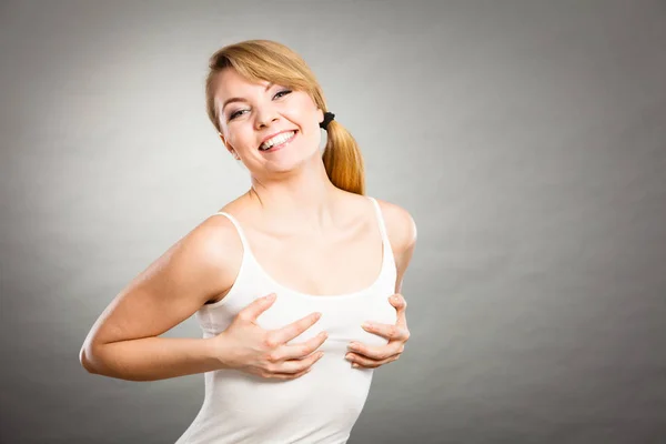 Радостная женщина, держащая руки на груди — стоковое фото