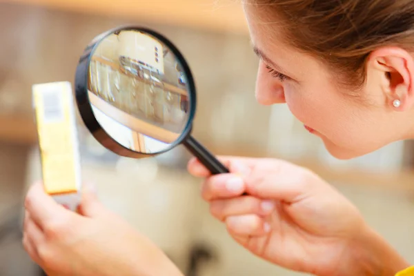 Mujer inspeccionando mantequilla con lupa . — Foto de Stock