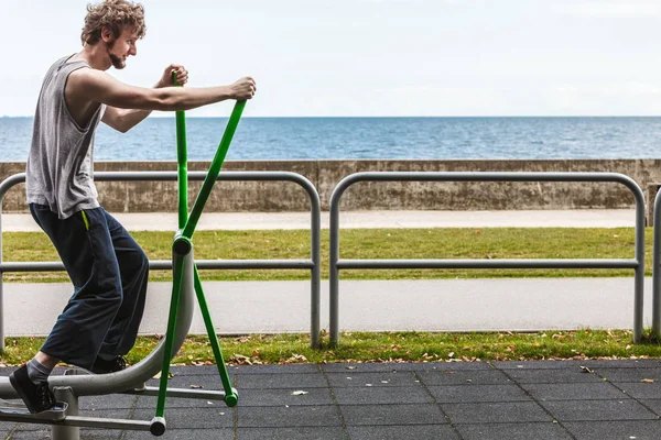 Active man exercising on elliptical trainer. — Stock Photo, Image