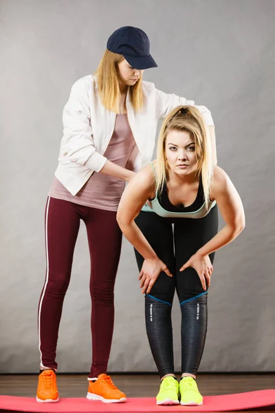 Donna in abbigliamento sportivo gambe stretching con allenatore — Foto Stock