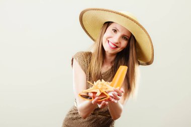 Kadın güneş gözlüğü ve güneş koruyucu losyon tutar