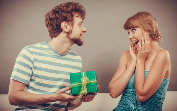 Young man giving woman gift box — Stock Photo, Image