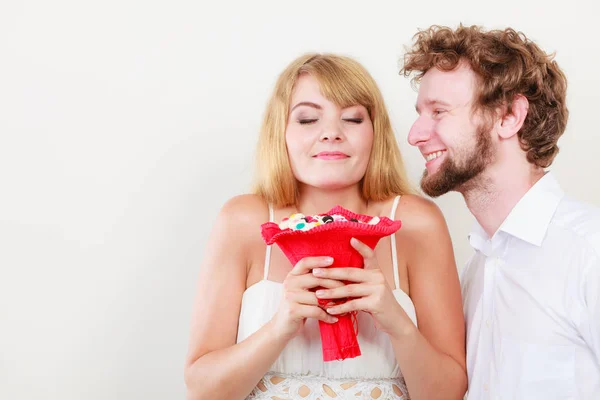 Glückliches Paar mit Süßigkeiten Strauß Blumen. Liebe. — Stockfoto