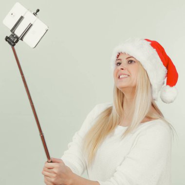 Santa şapka alarak fotoğrafını selfie stick kullanarak kız